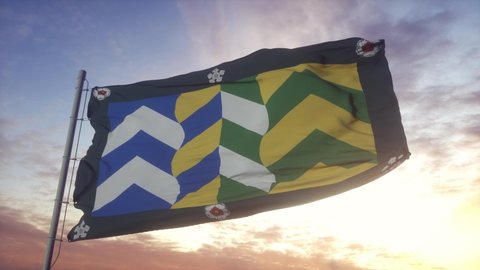 Cumbria flag, England, waving in the wind, sky and sun background