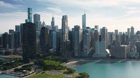 4K aerial of Milton Lee olive park and Ohio street beach at cinematic blue Michigan lake on beautiful Chicago downtown skyline background. Summer vacation in urban city, tourism background 4K USA