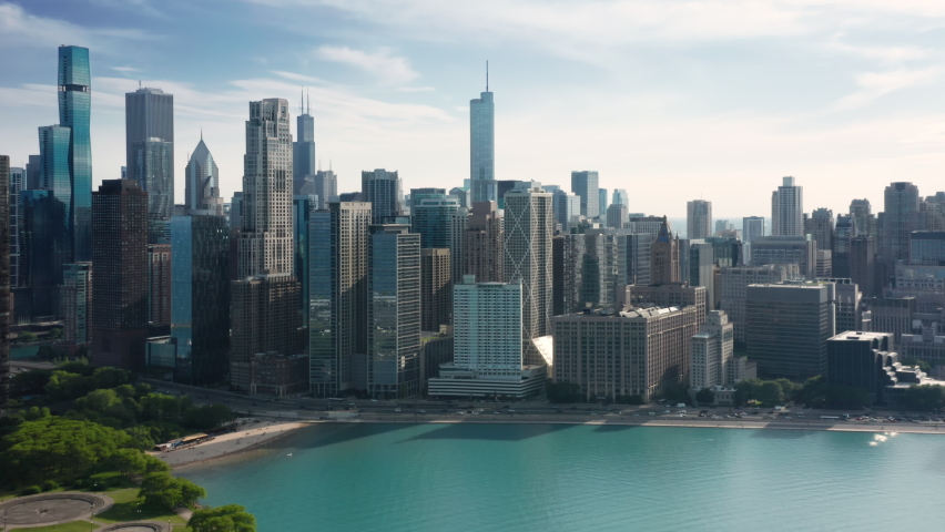 4K aerial of Milton Lee olive park and Ohio street beach at cinematic blue Michigan lake on beautiful Chicago downtown skyline background. Summer vacation in urban city, tourism background 4K USA