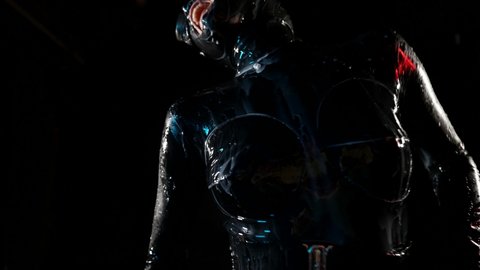 erotic fantasy with bdsm role play, woman in black latex suit is dancing in water flows