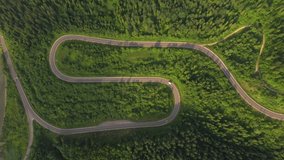 Top view from a helicopter flying over a winding road. Location place Carpathian mountains, Ukraine, Europe. Cinematic aerial shot. Explore the beauty of world. Filmed in 4k, drone video.