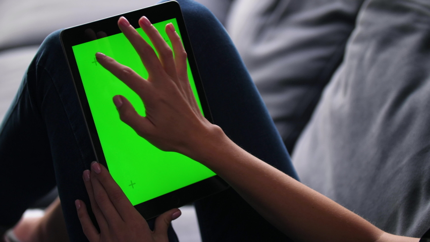 Closeup shots of green screen on iPad. Female person holds in hands portable tablet computer with moving green motion tracking points. Touching device screens surface with fingers, swiping and zooming Royalty-Free Stock Footage #1079272673