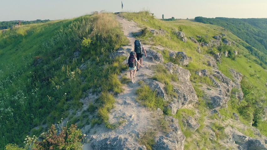 The two travelers climbing on the mountain trail. slow motion