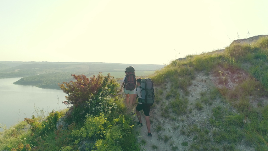 The two travelers trekking on the mountain trail