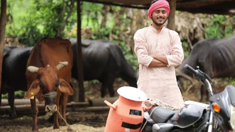 Rural scene : Indian milkman distribute milk on bike
