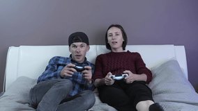 Happy excited couple enjoying video game, having fun at home. Modern devices and family activities concept. Friends holding joysticks and competition in intense video game on gaming console