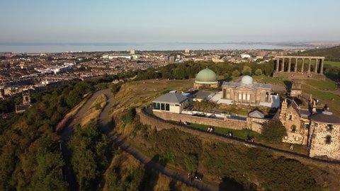 4K Aerial View of Edinburgh City Skyline, Castle, Observatory and Old Town taken by Drone from Calton Hill at Sunset (Scotland, UK)