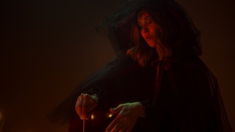 Witch woman sitting in pentagram circle and cooking potion. Evil sorceress making rite and sacrifices at night, using black witchcraft, cow skull and candles on floor. Halloween tradition, usa holiday