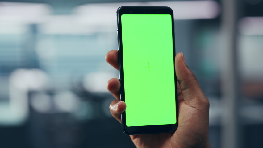 Black Man with Green Screen Chroma Key Smartphone in Office. African-American Person using Internet, Social Media, Online Shopping with Mobile Phone Device. Focus on Display, Hand Royalty-Free Stock Footage #1079293511