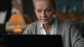 Happy old woman looking laptop computer in luxury interior. Smiling senior lady reading email on laptop in vintage room. Portrait business woman using computer at home office. Remote work concept - Powered by Shutterstock - Get 15% off with code: PIKWIZARD15