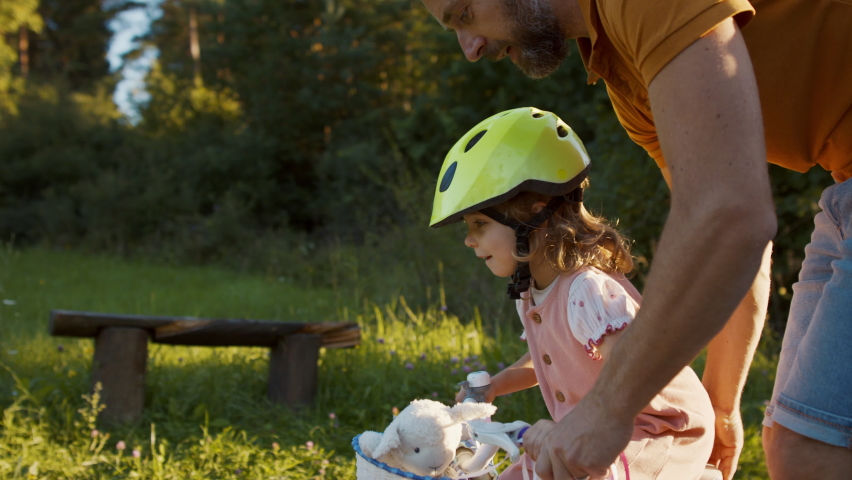 Father teaching his daughter how to ride a bike. Royalty-Free Stock Footage #1079297690