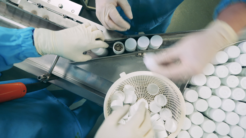 Pharmacologists are moving tubs with pill through the conveyor Royalty-Free Stock Footage #1079298113