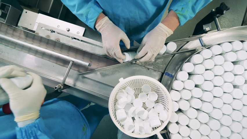 Pharmacologists are moving tubs with pill through the conveyor | Shutterstock HD Video #1079298113