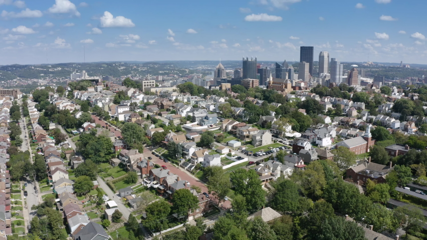 A slow orbiting summer aerial establishing shot of a Mount Washington residential neighborhood overlooking the city of Pittsburgh.  	 Royalty-Free Stock Footage #1079307161