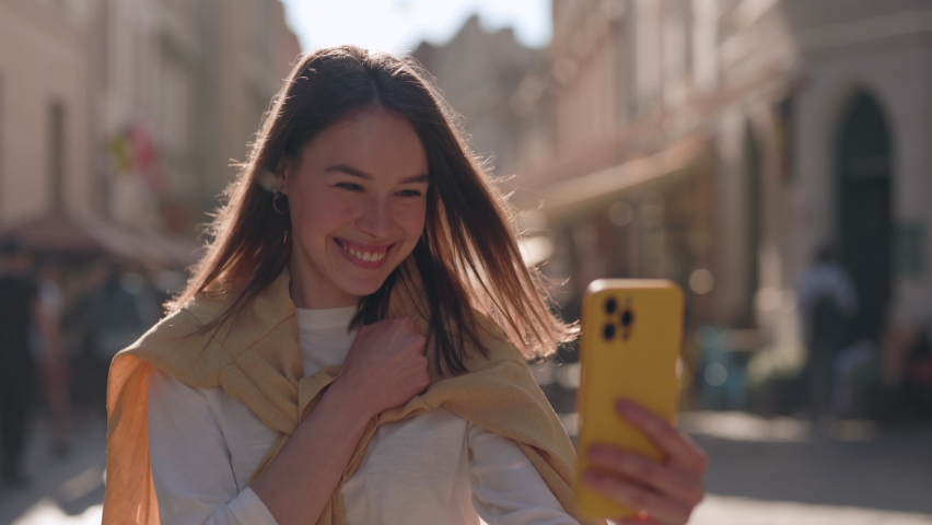Happy deaf woman walking on city street and showing with sign language phrase I miss you during video call on smartphone. Concept of hearing loss and modern technology. | Shutterstock HD Video #1079310566