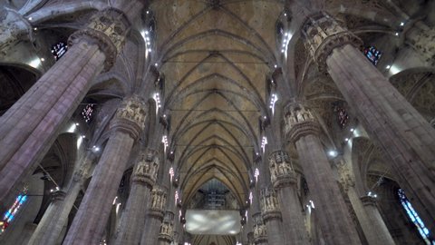 The interior of the Milan Cathedral. Tourists visiting the architecture of the famous church. Statues and columns inside the Duomo Cathedral, Italy. Steadicam filmed Italy, Milan, September 2021 