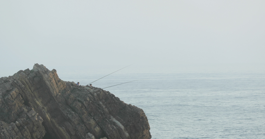 People On The Rocky Cliffs Fishing By The Seashore Of Sao Pedro De Moel In Leiria, Portugal. Static