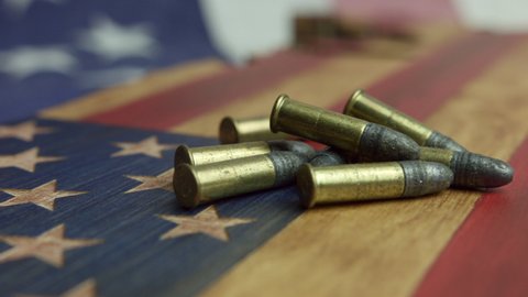 Pieces Of Caliber Bullets On Wooden Patriotic Table. Homeland Defense Concept. close up, slider shot
