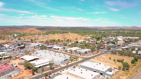 Alice Springs - Australia. Cinematic aerial flyover of outback city with red sad outback desert beyond. Filmed on DJI Mavic Pro.