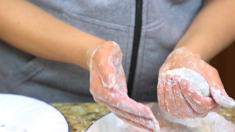 Slow motion of woman hands in starch cooking forming filling with chocolate homemade mochi sticky glutinous Japanese rice cake dessert at home kitchen