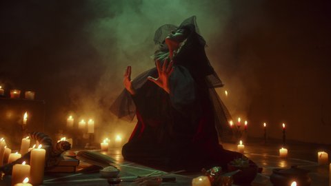 Witch woman sitting in pentagram circle and reading spell. Evil sorceress making rite and sacrifices at night, using black witchcraft, cow skull and candles on floor, full moon. Halloween concept. 