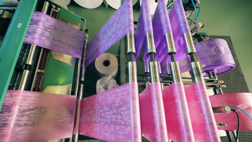 Top view of a colourful plastic bag manufacturing machine. Polyethylene film production process. | Shutterstock HD Video #1079343227