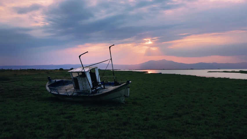 Cinematic shot of abandoned old fishing boat on the shore by wetland at national park.