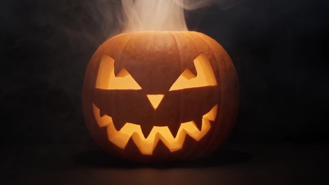 Pumpkin glows on Halloween night. Traditional Halloween symbol. Halloween pumpkin smile and scary eyes for party night. Horror Halloween concept.