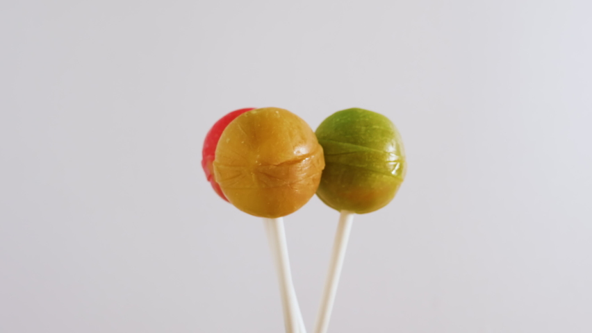 Three lolipop candies spinning on a white background, background from sweets Royalty-Free Stock Footage #1079348291