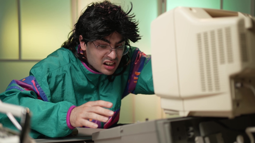 Frustrated nerd from the 80s getting angry at his home computer Royalty-Free Stock Footage #1079349680