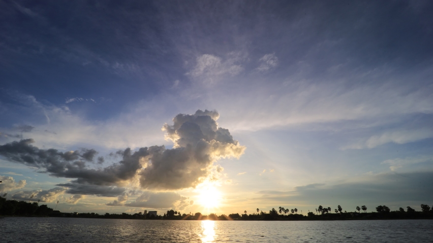 Time-lapse photography of evening sky, red, orange, yellow clouds over the river
