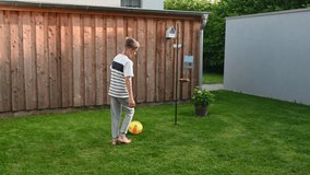 4K video of happy little boy practice his feint and tricks competition with ball at backyard at home during summer holidays