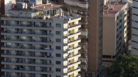 Malaga, Malaga Spain - 08 23 2021: Big building with people sunbathing and watching in the penthouse solarium 