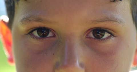 Kid face close-up closing eyes in meditation. Child boy opening eyes smiling to camera, macro closeup