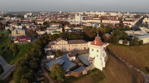 A flight around the old castle in Grodno with a panoramic view of the historical center, bridges and the Neman River. Aerial drone 4K video. Sunset twilight