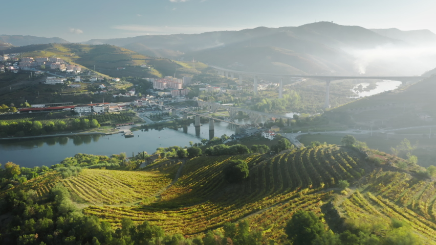 Panoramic view of city Peso da Regua located in green mountains in morning light, Vila Real, Portugal, Europe. Bridges over river situated two parts of city. Wine region in Douro valley, 4k footage Royalty-Free Stock Footage #1079370758