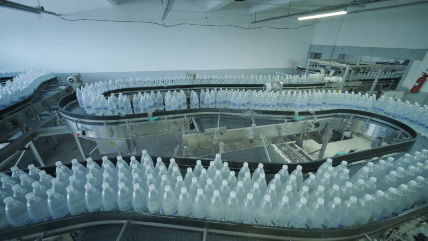 Conveyor belt with bottles of drinking water at a modern beverage plant | Shutterstock HD Video #1079371568