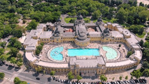 Szechenyi Bath aerial view. Drone flies around pool with many visitors.