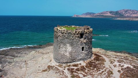 Aerial 4K video of nuraghe in a island in Stintino, La Pelosa beach in Mediterranean sea. The nuraghe or also nurhag in English, is the main type of ancient megalithic edifice found in Sardinia.