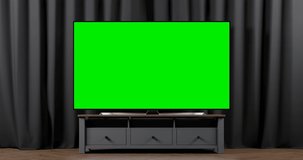 The camera slide to the green screen of a modern TV set on the cupboard