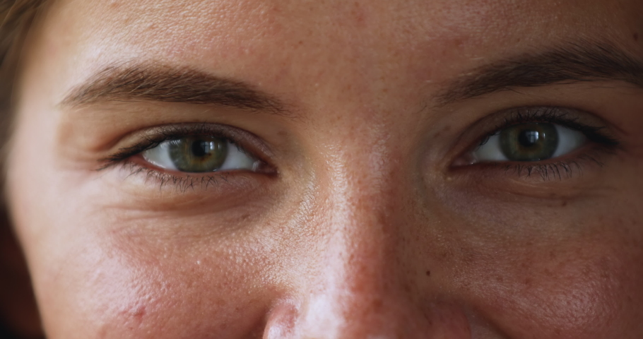 Gaze. Beautiful green eyes of young smiling female looking at camera. Macro view of attractive millennial woman happy face with opened eyes thick eyebrows cute freckles on smooth skin. Cropped closeup | Shutterstock HD Video #1079380532