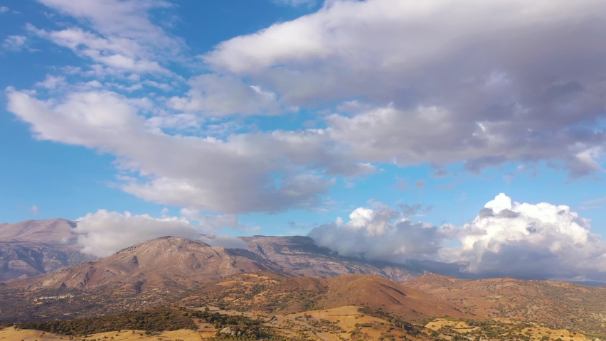 Aerial view of Crete island, Greece. Mountain landscape, olive groves, cloudy sky in sunset light.