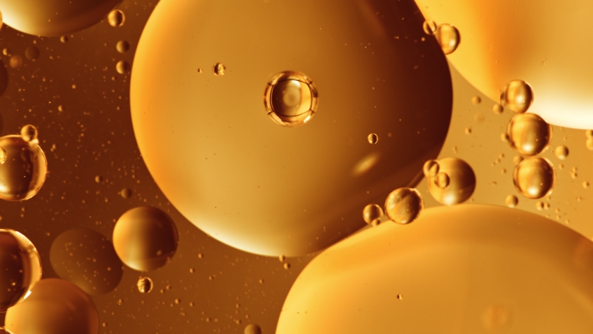Super Slow Motion Shot of Moving Oil Bubbles on Golden Background at 1000fps. Royalty-Free Stock Footage #1079385305