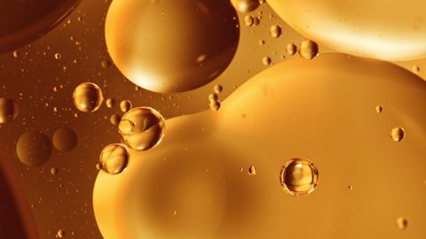 Super Slow Motion Shot of Moving Oil Bubbles on Golden Background at 1000fps.