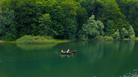 Young couple are sailing on a boat in Biogradsko Lake in Montenegro. Aerial view 4K.の動画素材