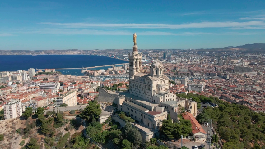 Marseille, France aerial video with view of basilica Notre Dame de la Garde, old city center and port and blue Mediterranean sea coast, warm sunny day. Summer holiday vacation tourism destination. Royalty-Free Stock Footage #1079400410