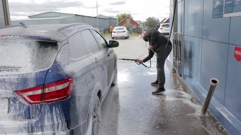 Russia, Naberezhnye Chelny 09.19.2021: a man washes Lada Vesta's car at a car wash