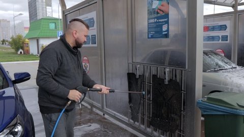 Russia, Naberezhnye Chelny 09.19.2021: a man washes Lada Vesta's car at a car wash
