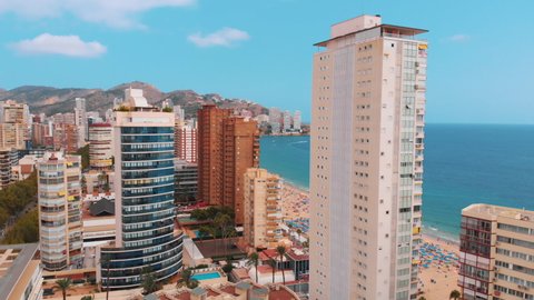 Benidorm, Spain 18.08.2021 High rise buildings in Benidorm, Spain Aerial footage. Mountains touching the picturesque blue sky in the background. Benidorm is known for beaches and Skycrapers.