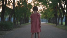 little girl is riding hoverboard or electric self balancing scooter board on the side walk. child controls the Self-balancing scooters in summer. New hobbies of children with technology hoverboard. - Powered by Shutterstock - Get 15% off with code: PIKWIZARD15